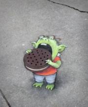 Manhole street art eating oreo cookie